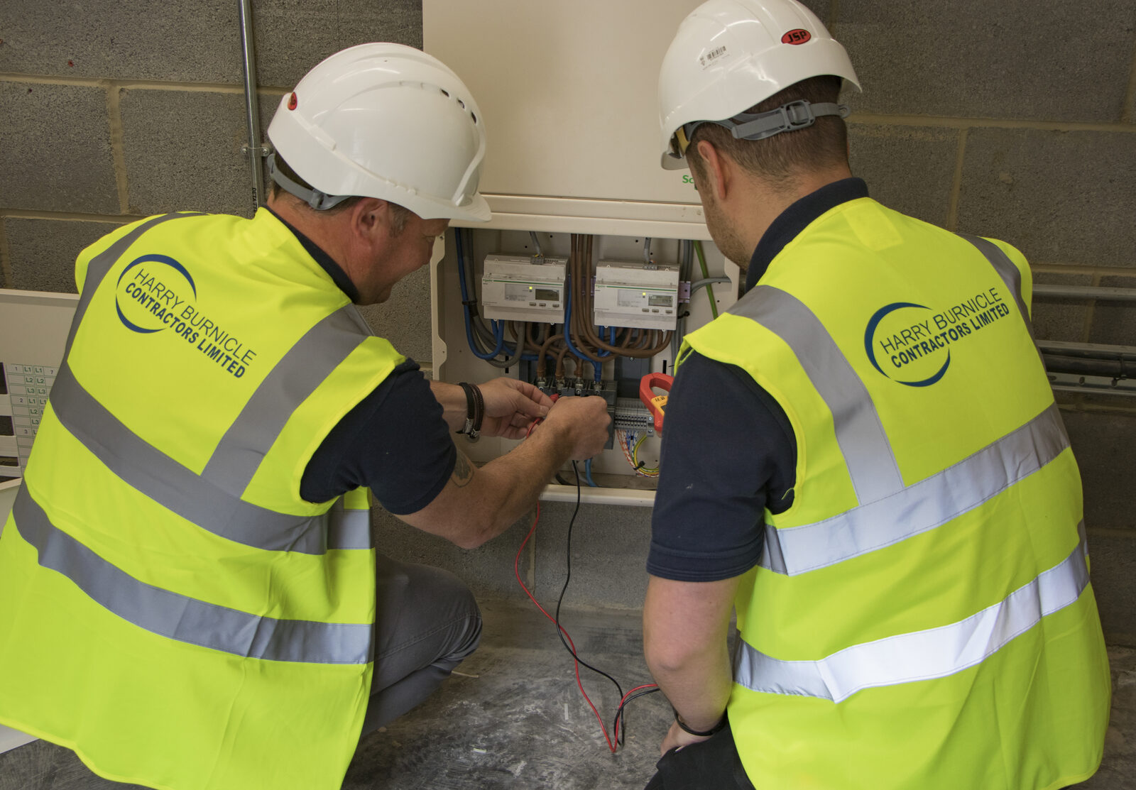 Two Harry Burnicle electricians testing a distribution board
