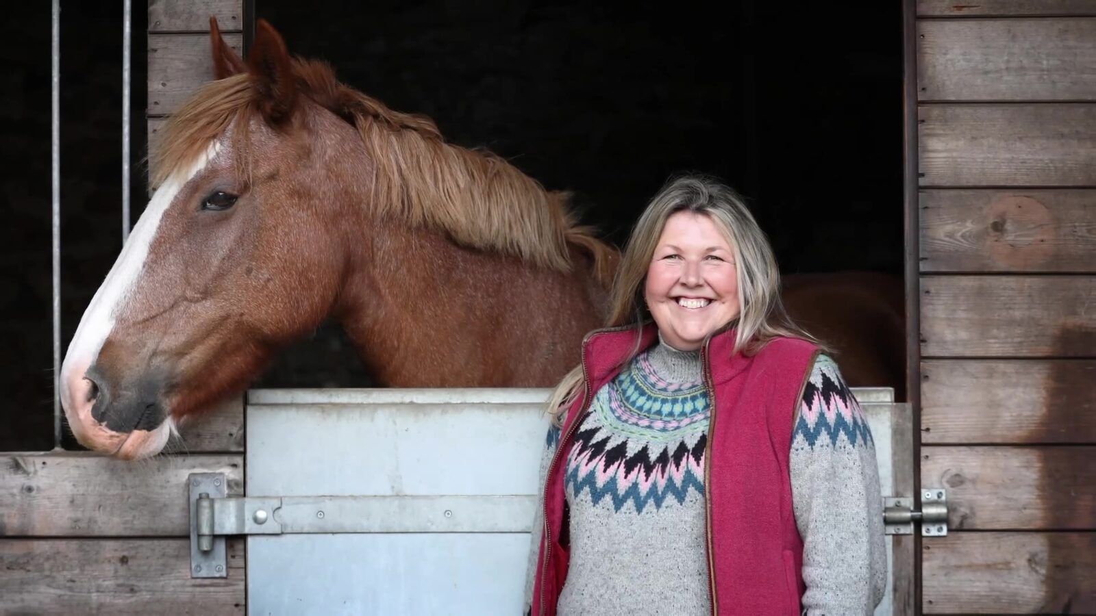 Business owner with her horse at a stable yard