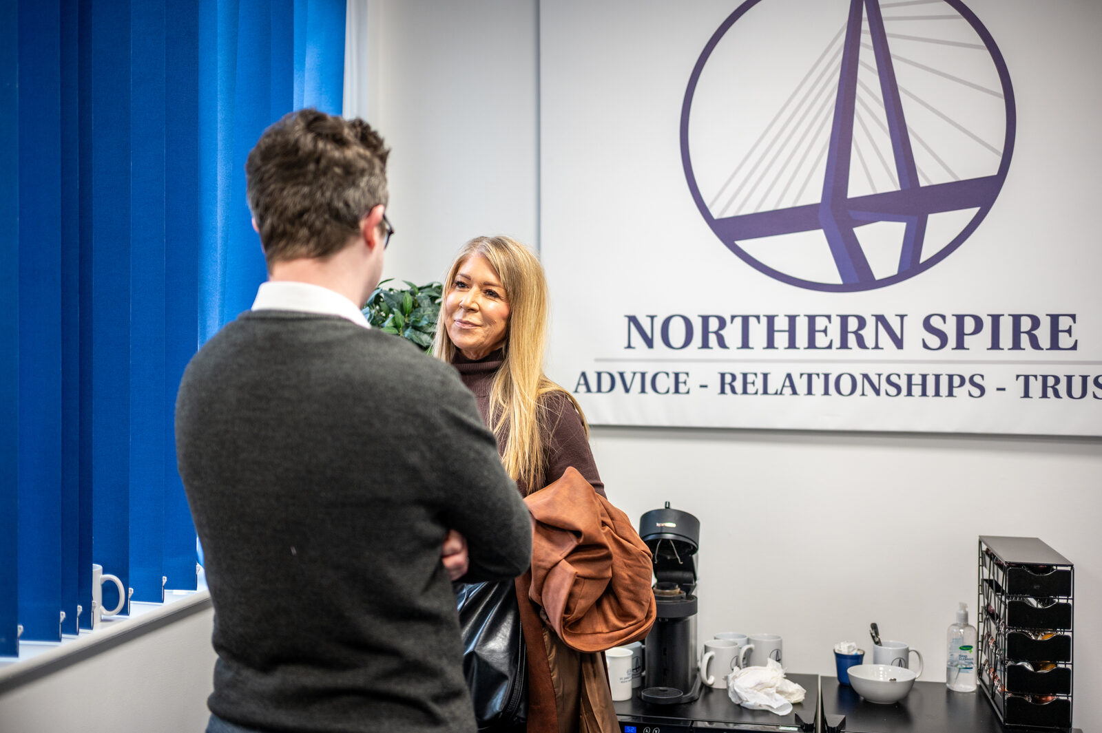 Networking in front of the Northern Spire logo wall